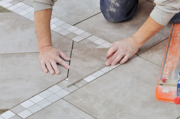 Professional tile flooring installation by local experts in Lakeline OH, showcasing a worker laying tiles with precision in a modern space.