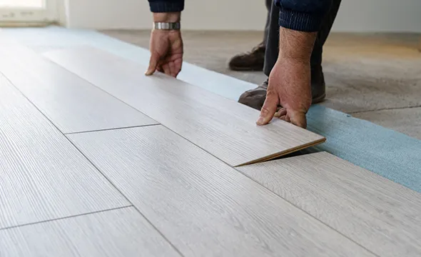 Close-up of professional laminate floor patching in Willwick OH, showing a worker installing trusted waterproof laminate flooring with precision.