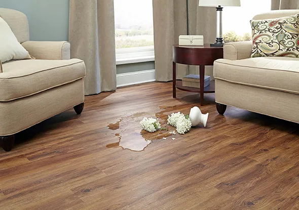 Modern living room with trusted waterproof laminate flooring in Willwick OH, featuring a cozy couch, coffee table, and large window with natural light.