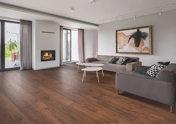 Bright and elegant living area featuring engineered wood flooring, a comfortable couch, and decorative plants.